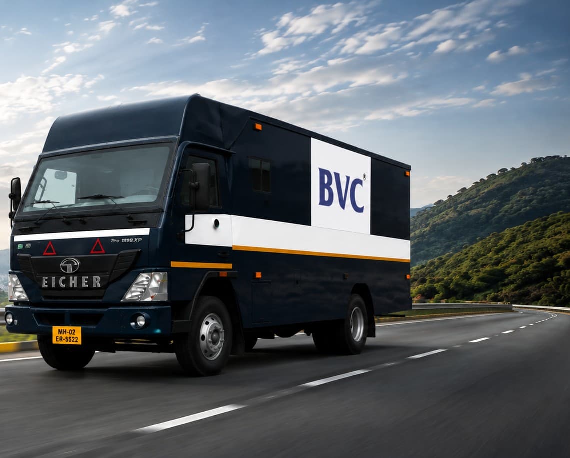 A BVC blue container truck on the highway with a city skyline behind