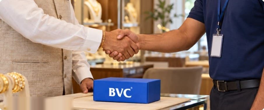 A jeweller shaking hands with a BVC executive over a BVC-branded parcel at a jewellery store counter