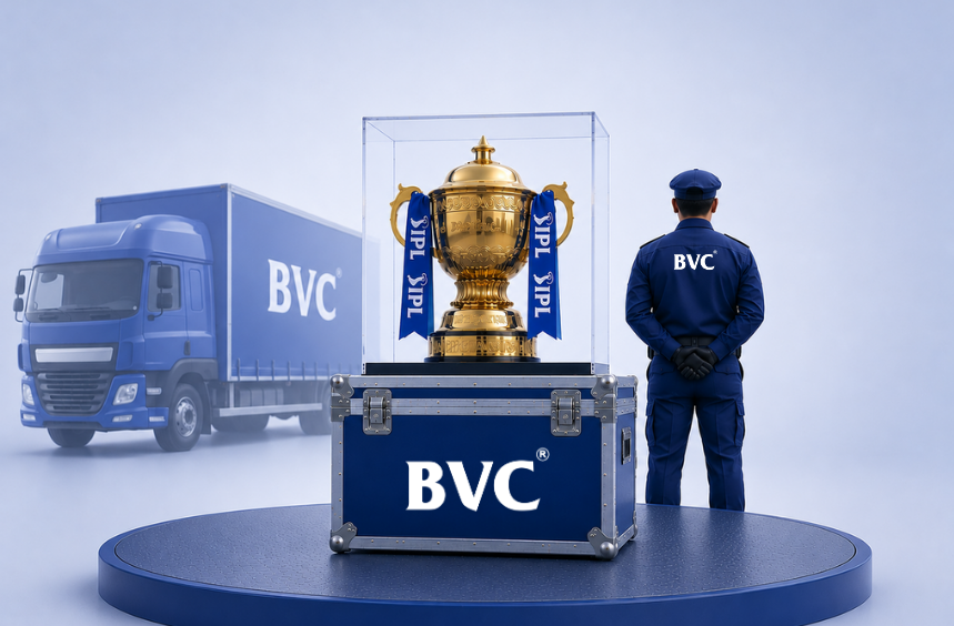 A gold IPL trophy in a glass case atop a blue BVC flight case, guarded beside a BVC truck