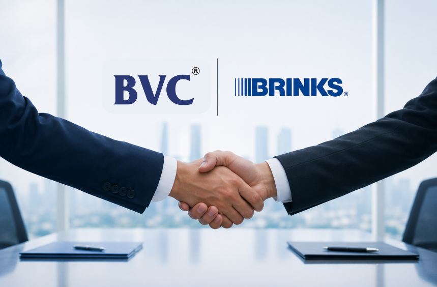 Two executives shaking hands beneath the BVC and Brink's logos in a city boardroom
